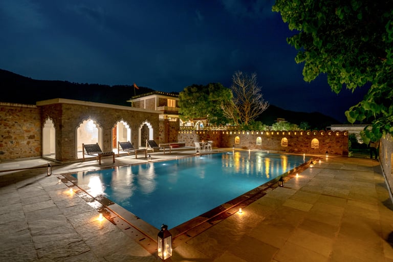 Infinity pool lit by lanterns after sunset
